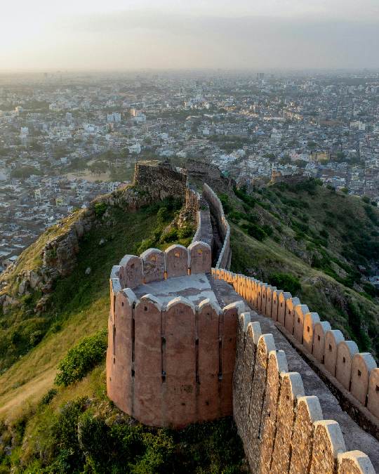 Imagen de un folleto turístico que presenta opciones para explorar Rajasthan. Incluye detalles sobre paquetes de tour por Rajasthan, un paquete de tour específico para Jaipur, y diversos paquetes turísticos de Rajastán, con fotos de monumentos y paisajes icónicos de la región.