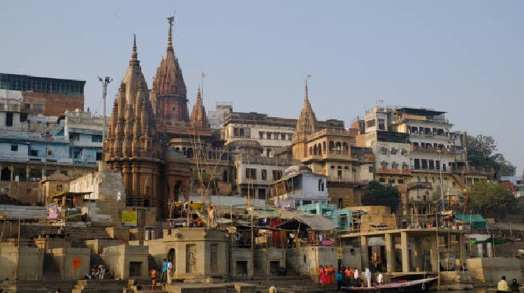 A scenic view of Varanasi showcasing its famous temples and vibrant ghats, highlighting popular tourist places in Kashi, with visitors exploring the best spots to visit in Varanasi.