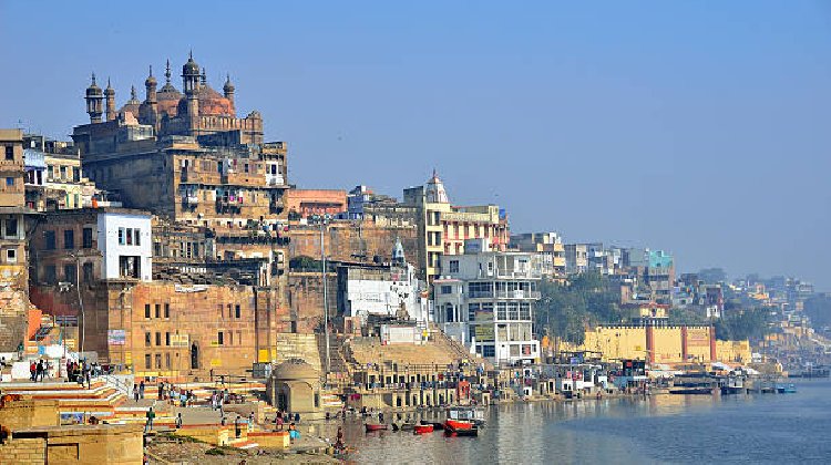 A scenic view of Varanasi showcasing its famous temples and vibrant ghats, highlighting popular tourist places in Kashi, with visitors exploring the best spots to visit in Varanasi.